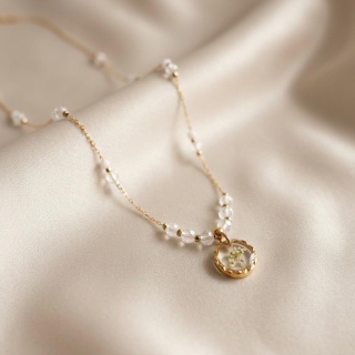 Naszyjnik z żywicy Aura z kwiatami dzikiej marchwi i kryształem górskim