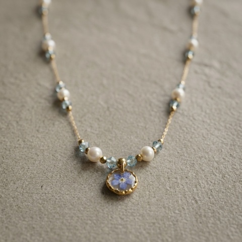 Naszyjnik z żywicy Aura z suszoną niezapominajką, topazem i perłami